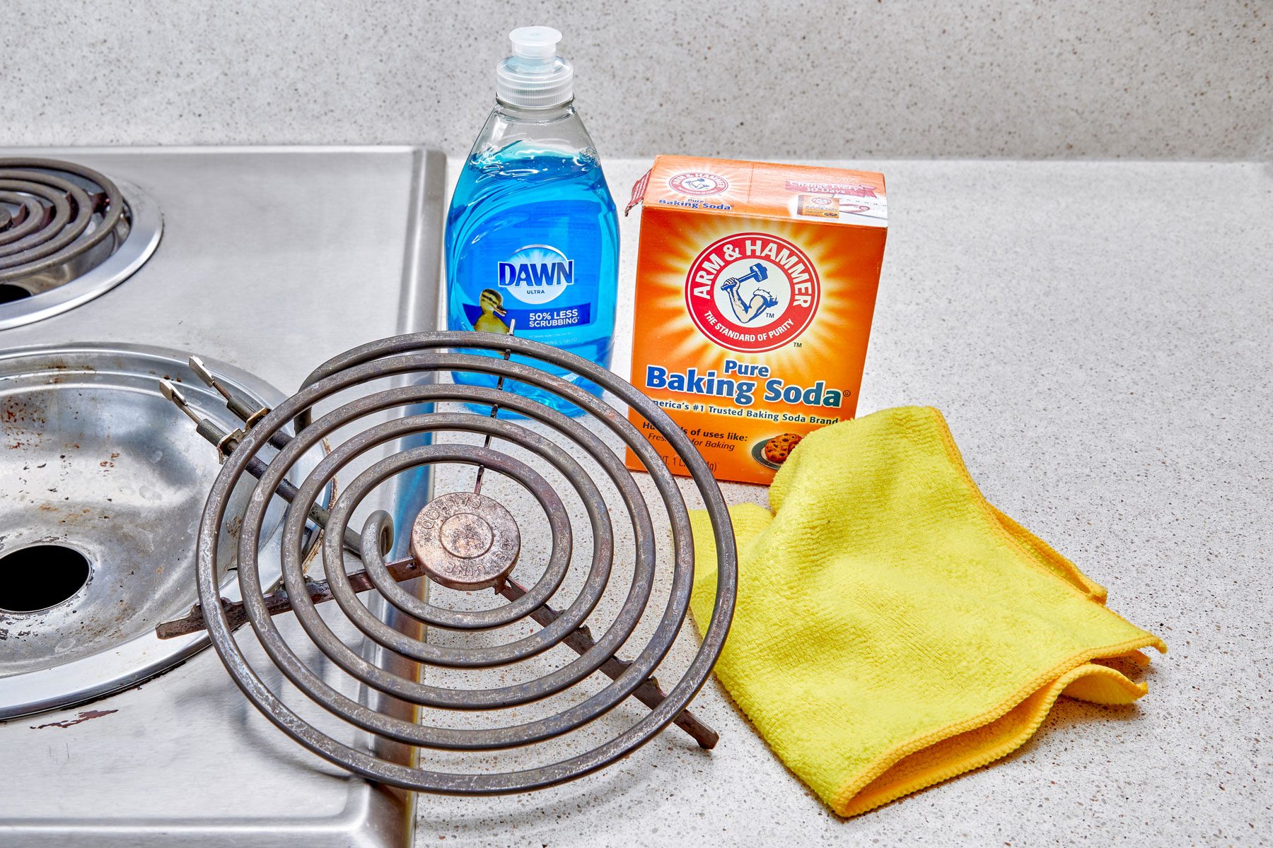 removed electric stove coil arranged near cleaning supplies