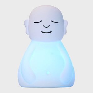 A smiling, glowing white figure sits contentedly, emanating a soft blue light, against a plain background.