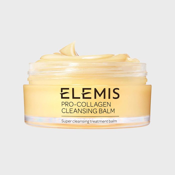 A jar contains yellow cleansing balm labeled 