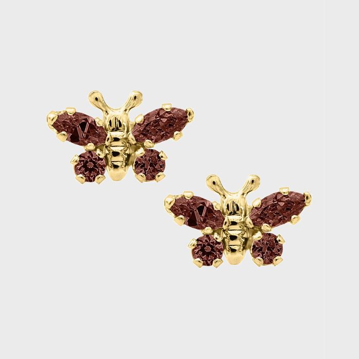 Gold butterfly earrings feature maroon gemstones as wings, set against a plain, light gray background.