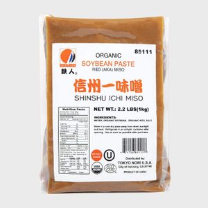 Packaged miso paste sits sealed, featuring detailed labels with nutritional facts, organic certification, and ingredients. The package highlights 