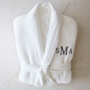 A white waffle-textured bathrobe, embroidered with 