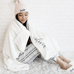 Person sitting while wrapped in a white blanket with 