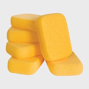 Five yellow sponges are stacked together, slightly leaning, against a plain white background.