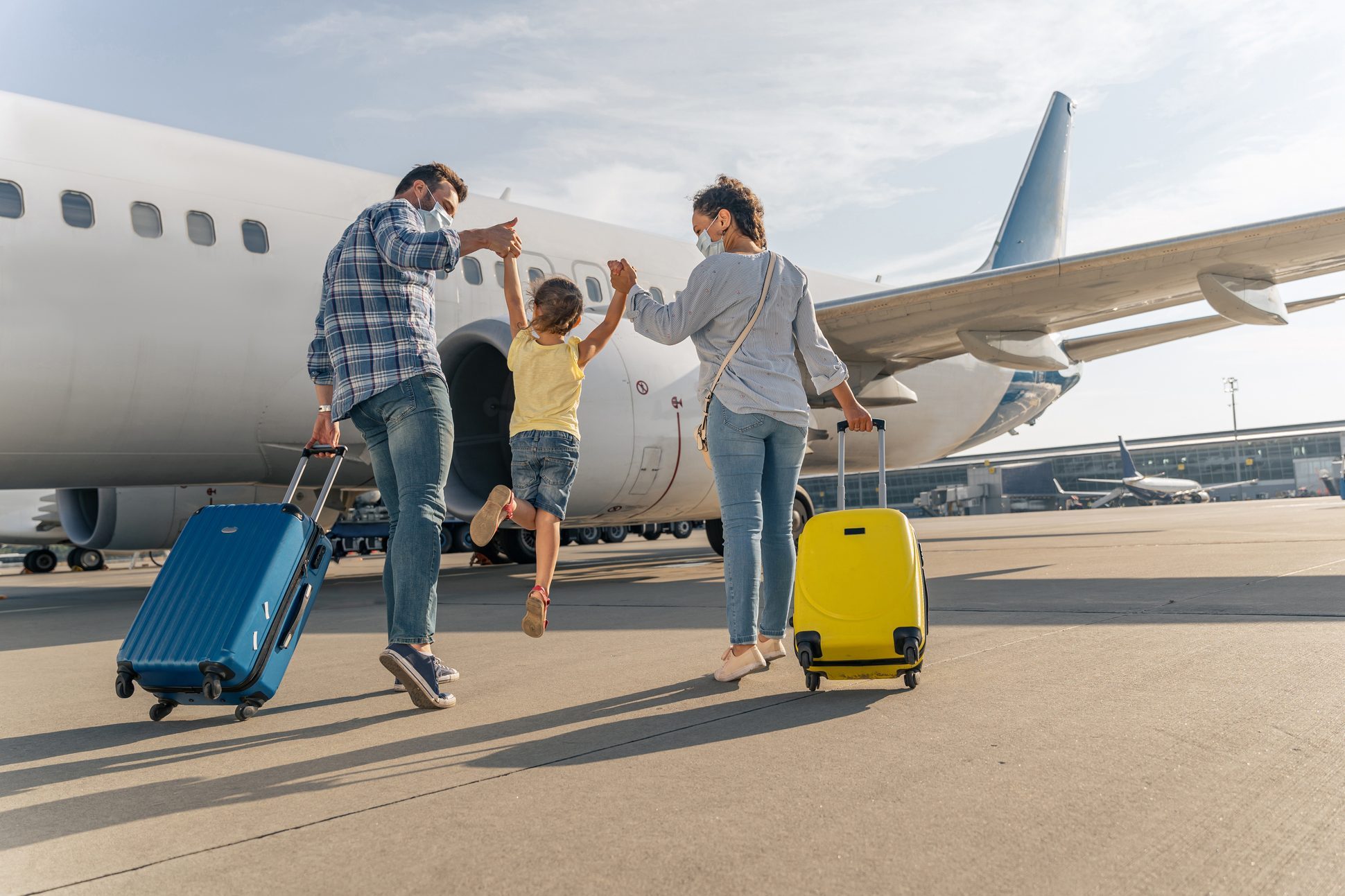 Happy family in masks enjoying travel together