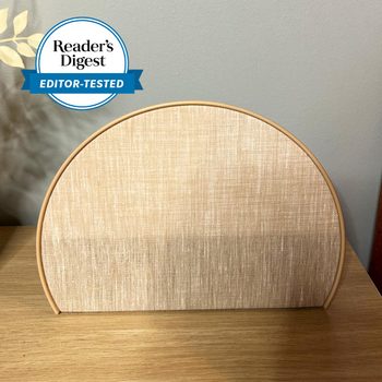 A half-circle object stands on a wooden surface, decorated with a textured fabric. "Reader's Digest EDITOR-TESTED" label is in the upper left corner.