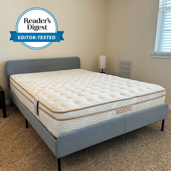 Mattress rests on a gray bed frame in a carpeted bedroom; labeled 