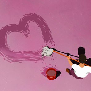 Person is mopping a heart shape onto a pink floor, with a bucket nearby, viewed from above.