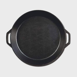 A black cast iron pan rests on a plain white background, featuring two side handles.