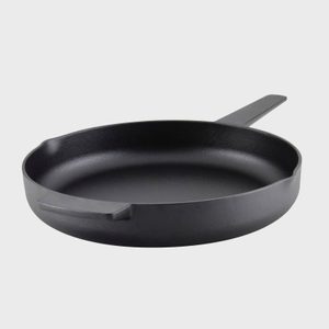 A black cast iron skillet rests on a plain white background.
