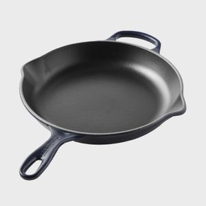 Cast iron skillet sits angled on a light background; 