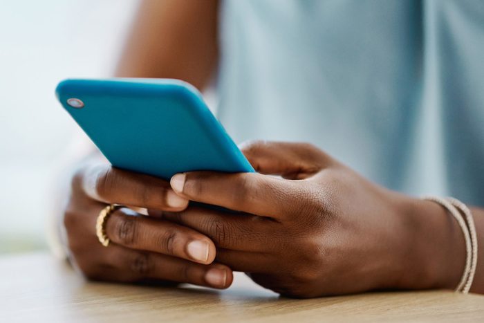 African woman using a cellphone in an office alone