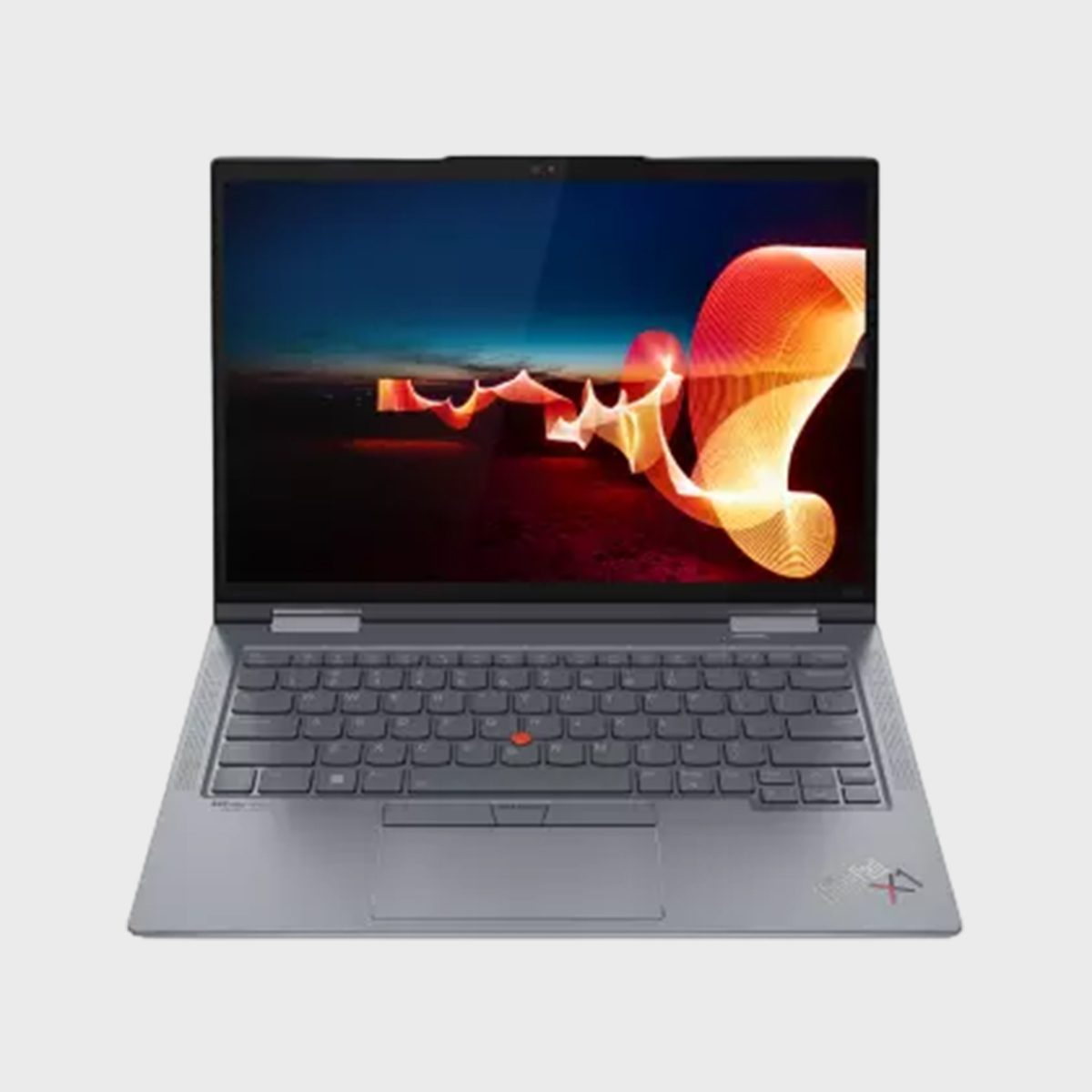 Laptop displaying abstract orange wave shapes on screen, open on a light gray surface in a well-lit environment.