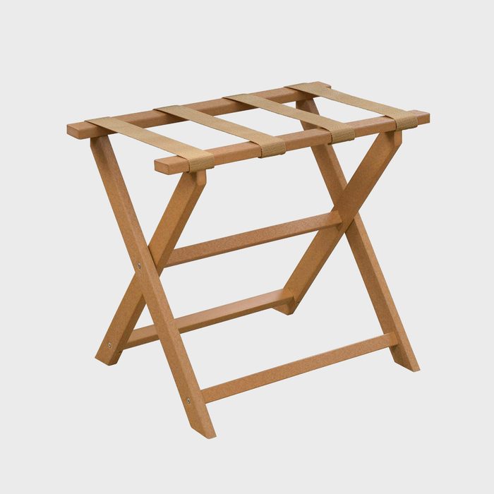 A wooden luggage rack with crossed legs and fabric straps sits on a plain white background.
