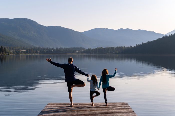 Family practising yoga outdoors