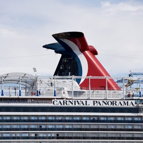 Cruise ship is docked; features a red, white, and blue funnel with the text 