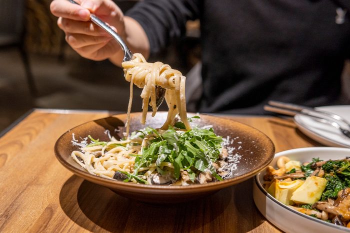 offering to share pasta on a fork at an Italian restaurant