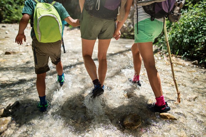 Happy family hiking in a river