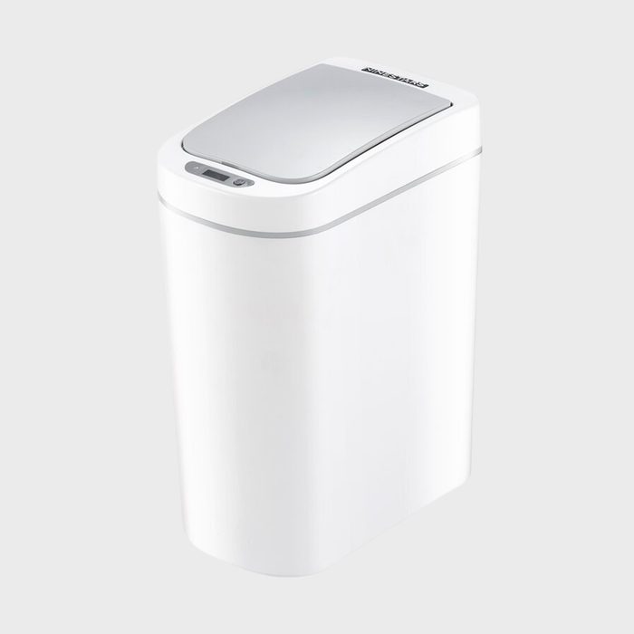 Trash can stands closed, featuring a sleek, modern design with a stainless steel lid, in a minimalistic setting.