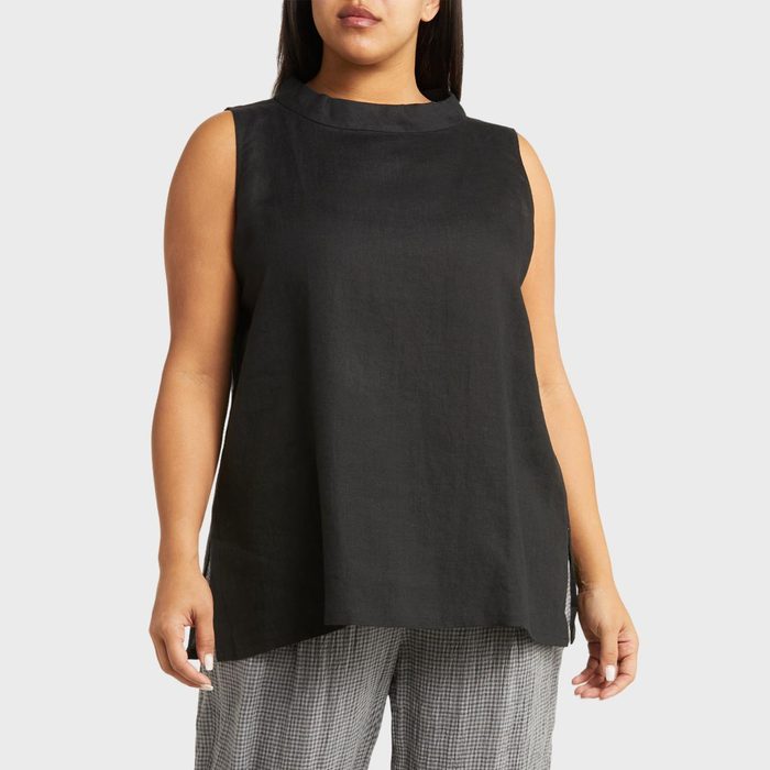 Sleeveless black top worn by a person, paired with checkered pants against a plain light gray background.
