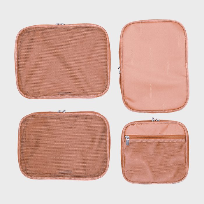 Four orange travel pouches are arranged in two rows, two with mesh tops and two with solid tops, featuring zippers.