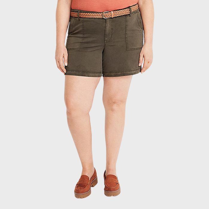 A person wears olive shorts, an orange belt, and loafers, standing against a plain light background.