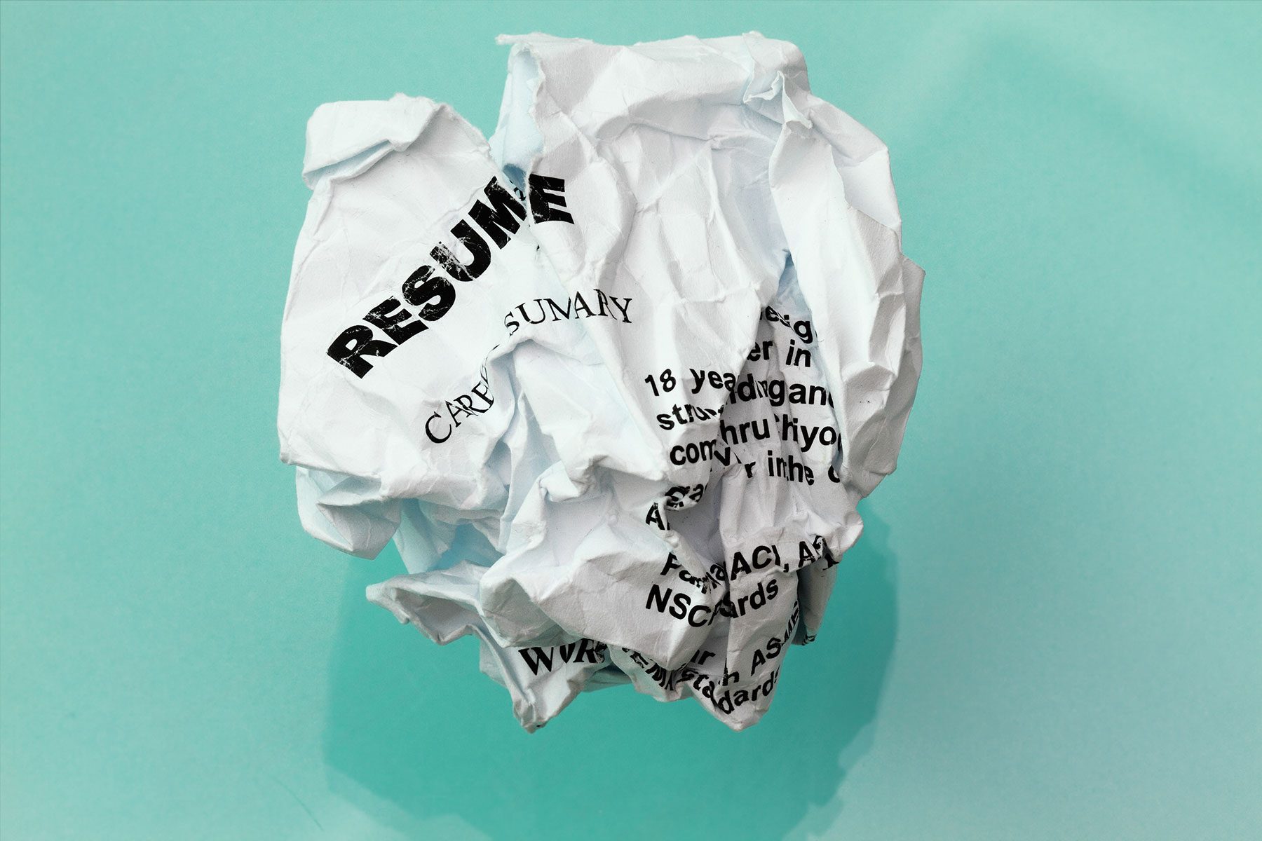 resume crumpled in cyan background with reflection and shadow