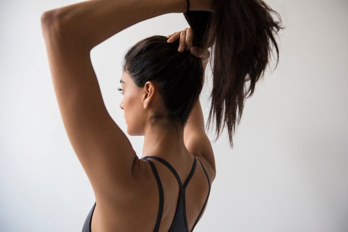 Indian woman putting hair in ponytail