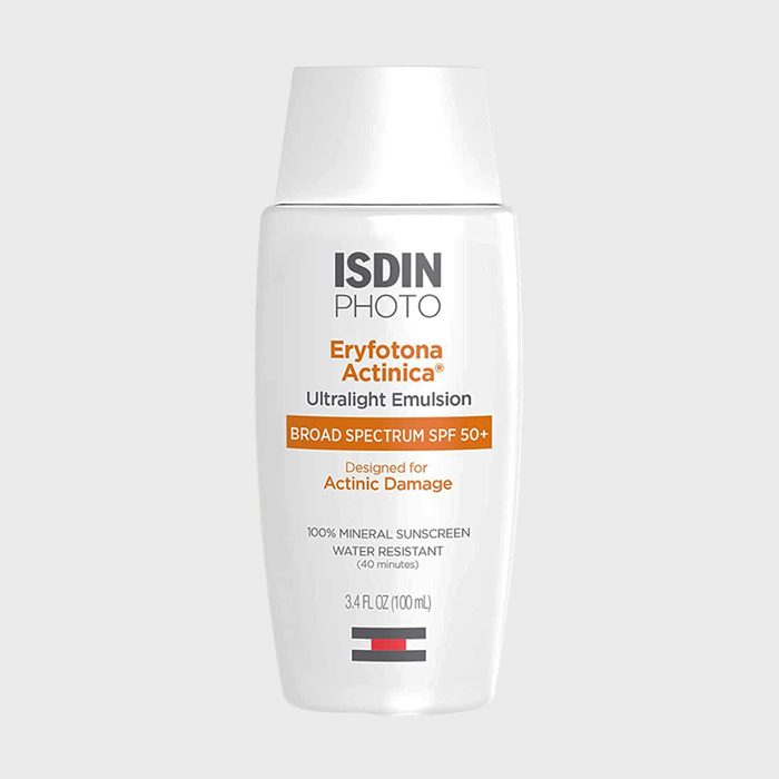 A white bottle displays sunscreen details; it's labeled broad spectrum SPF 50+, designed for actinic damage, with mineral and water-resistant properties.