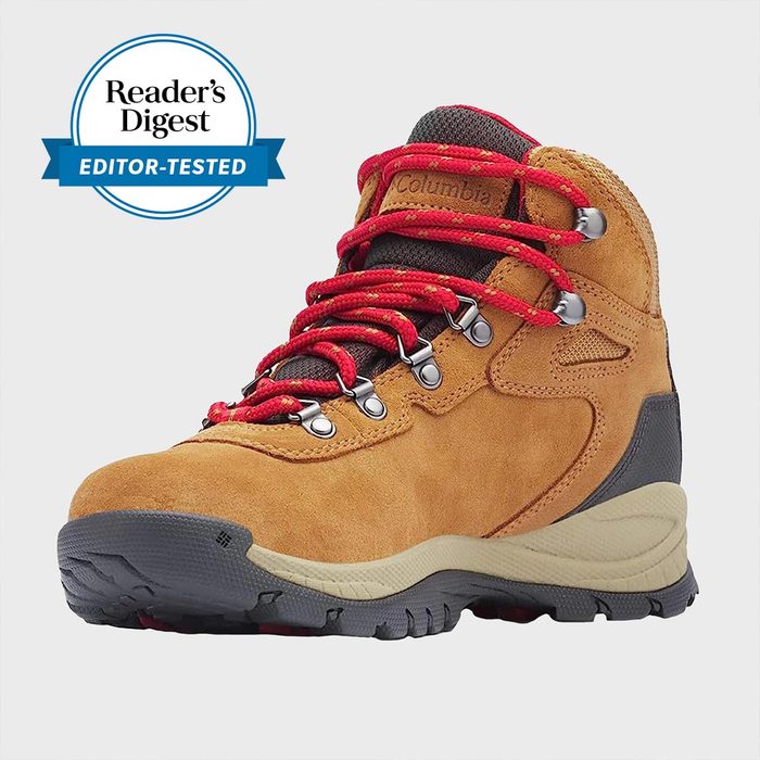 Boot sits on plain background with red laces, brown suede, and rugged sole; labeled 