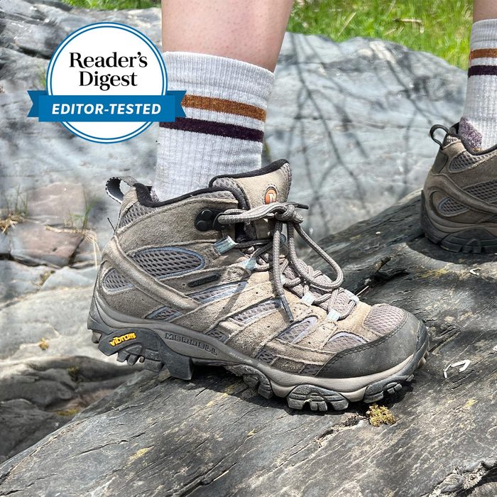 Hiking boot stepping on rocky surface, surrounded by greenery. Text reads: 