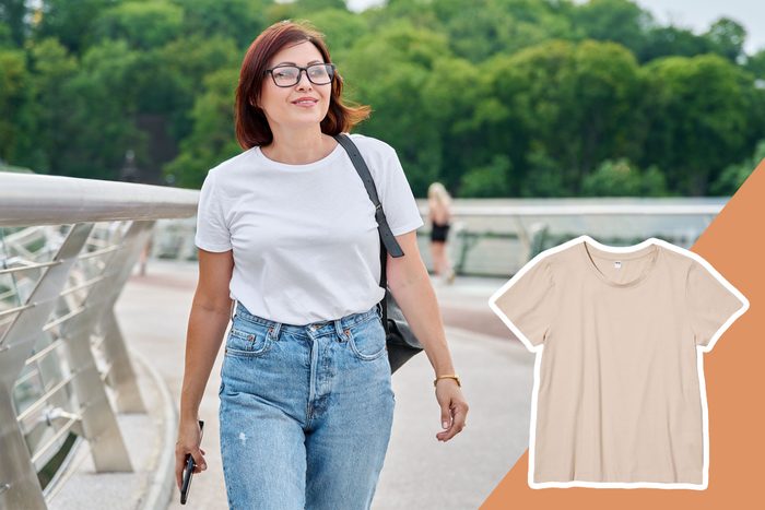 Woman walks on a bridge holding a phone; lush trees in the background. Beige t-shirt image overlays the bottom right corner.