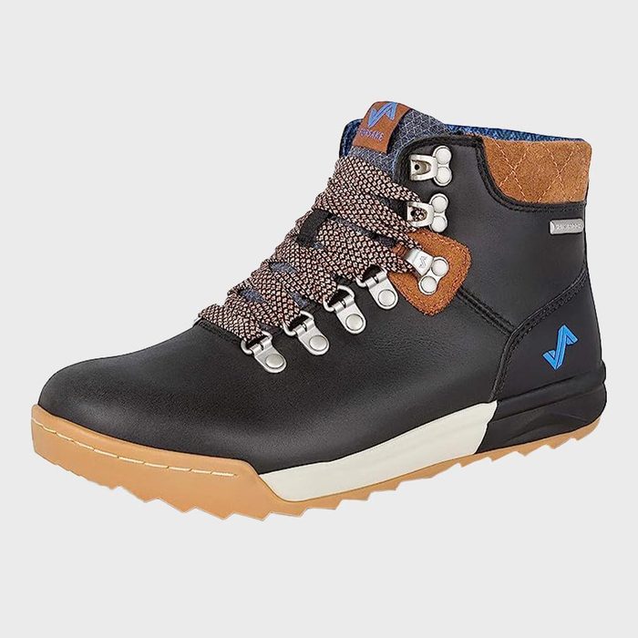A black hiking boot with brown accents features patterned laces, metal eyelets, and a rugged tan sole, set against a plain background.