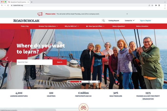 People stand smiling on a sailboat deck, under sunny skies, with text overlay: 