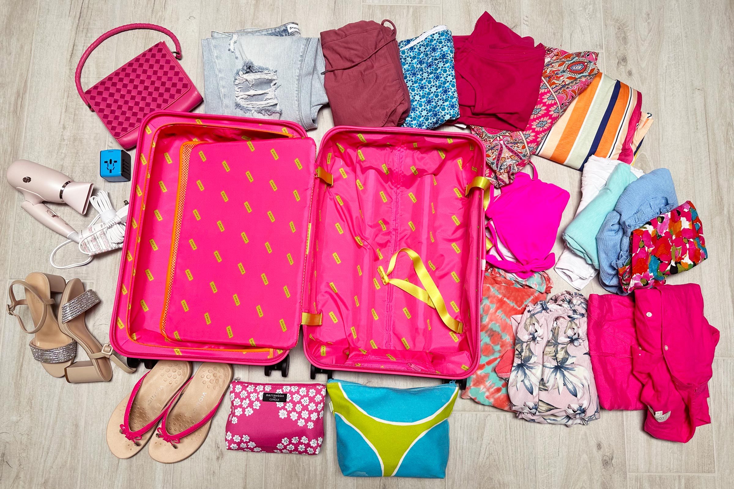 Away Carry On with everything hat can fit in the suitcase spread out around it on the floor