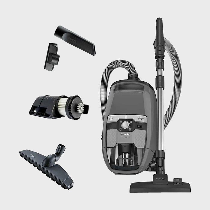 Vacuum cleaner with attachments displayed; includes hoses and cleaning tools, set against a plain background. Text: 