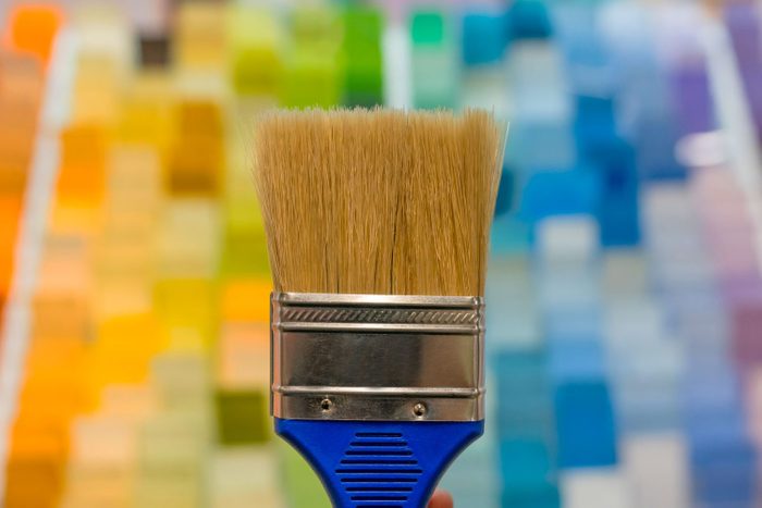 Paintbrush in from of a background of paint chips in a home improvement store