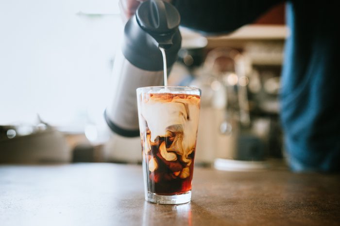 Barista Pours Milk Into Cold Brew Coffee