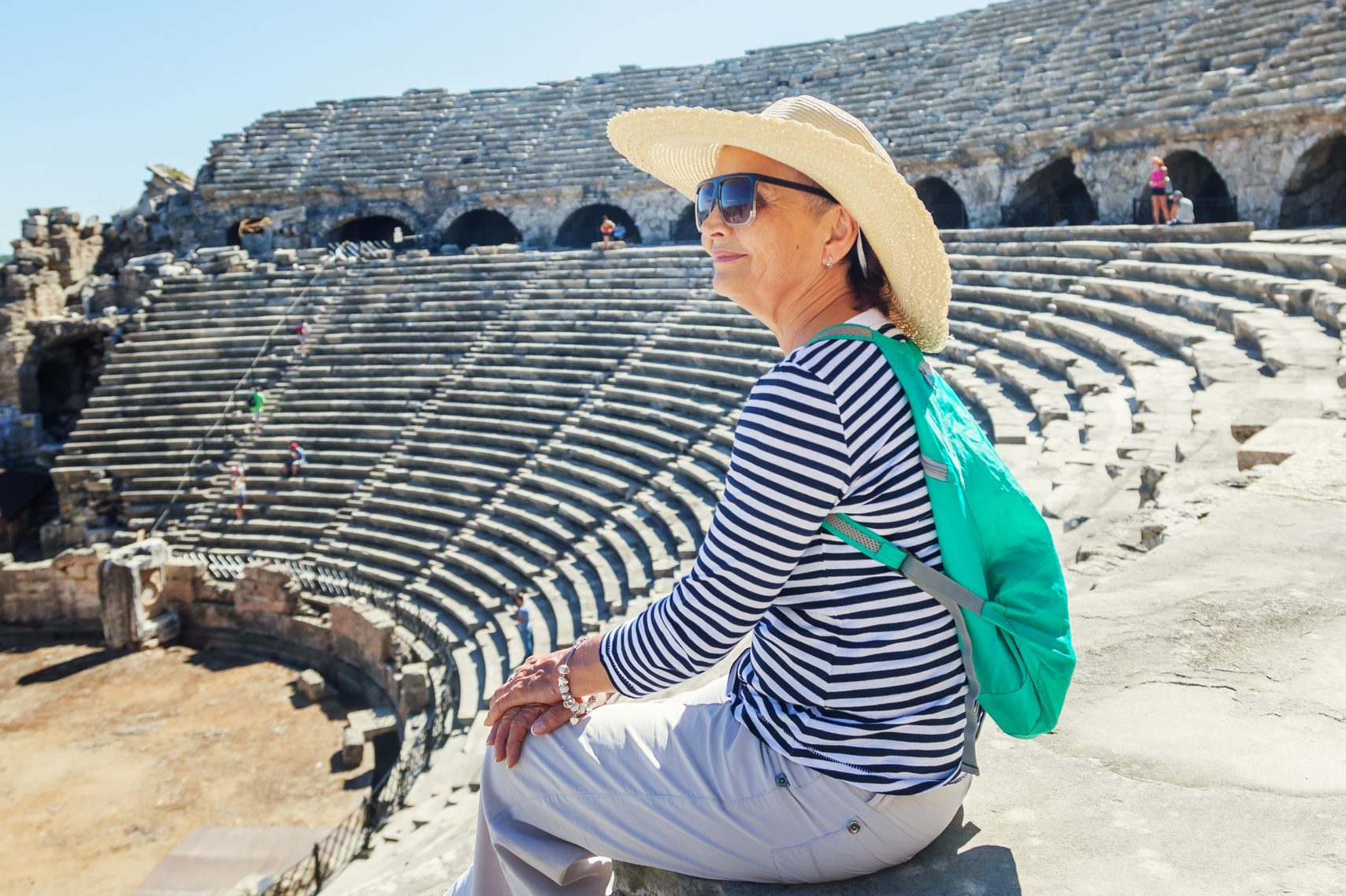 Mature woman sits on the steps of the monuments of Greece