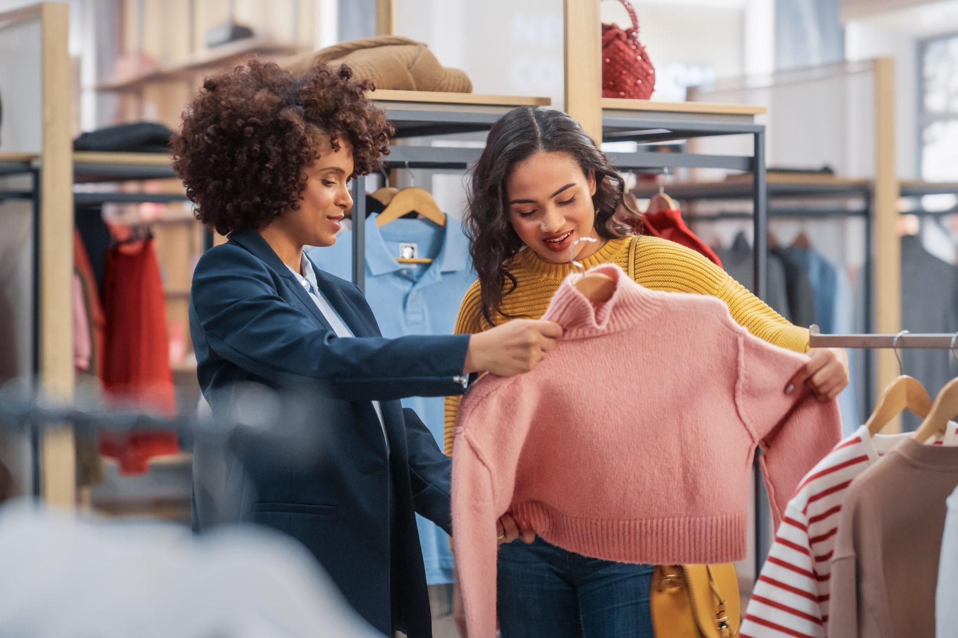 Young Female Customer Shopping in Clothing Store, Retail Sales Associate Helps with Advice. Diverse People in Fashionable Shop, Choosing Stylish Clothes, Colorful Brand with Sustainable Designs