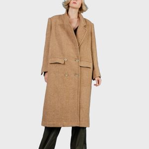 A person wears a long, tan overcoat with button details, standing against a plain white background.