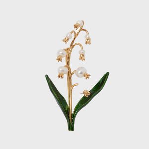 Gold flower brooch adorned with pearl-like accents, styled as lily-of-the-valley, set against a plain white background.