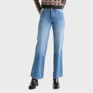 Blue jeans hang, unworn, over black boots against a plain background, complemented by a patterned sweater visible at the waist.