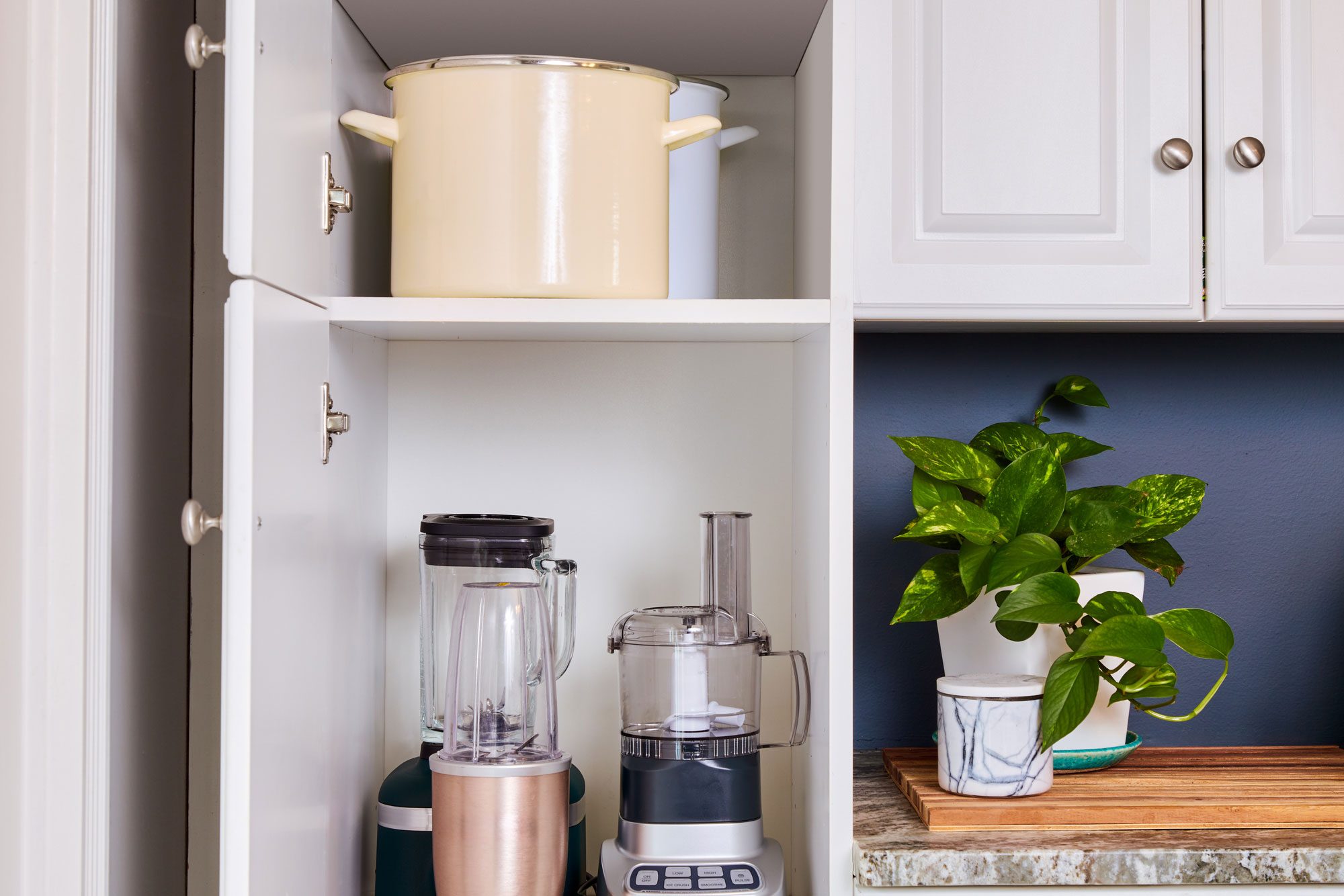 tall pot in cabinet near small, tall appliances