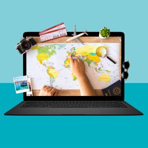 Laptop screen displays a world map with hands pointing; surrounded by travel items like a camera, airplane model, and tickets.