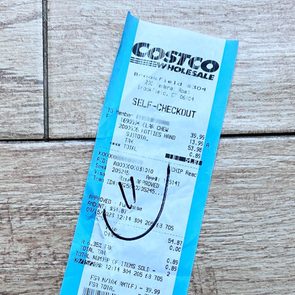 Receipt lies on the wooden floor; it displays various purchase details, including a smiley face drawn in black ink.