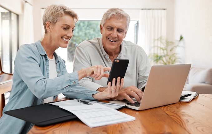Phone,,laptop,and,finance,with,a,senior,couple,working,on