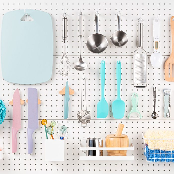 Kitchen Utensils Hanging On White Pegboard