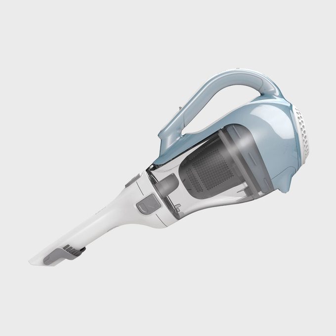 Handheld vacuum cleaner lays diagonally, showing transparent dust container, against a plain gray background.