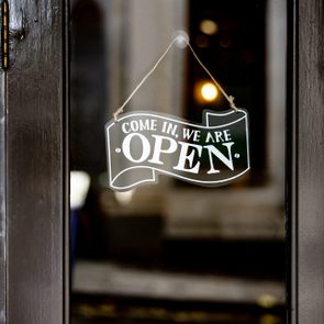 Sign hangs on glass door, reads 